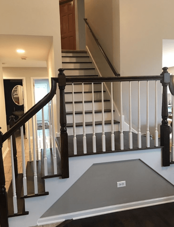 Dark wood staircase with white spindles and risers leading to an upper floor landing.